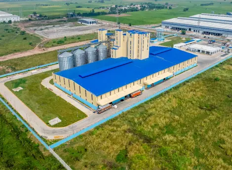 De Heus India modern animal feed mill with silos, production plant, and truck loading area.