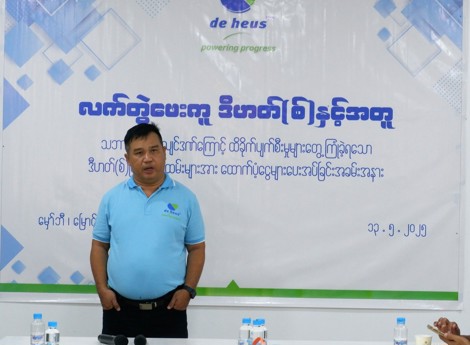 a man is standing in front of a backdrop at the event about myanmar earthquake support program.