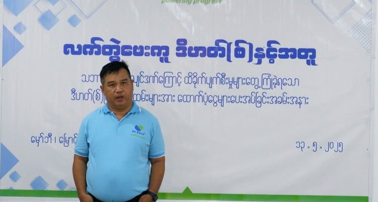 a man is standing in front of a backdrop at the event about myanmar earthquake support program.