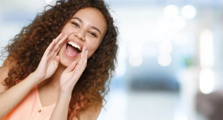 a lady is shouting and smiling in the office by using her hands