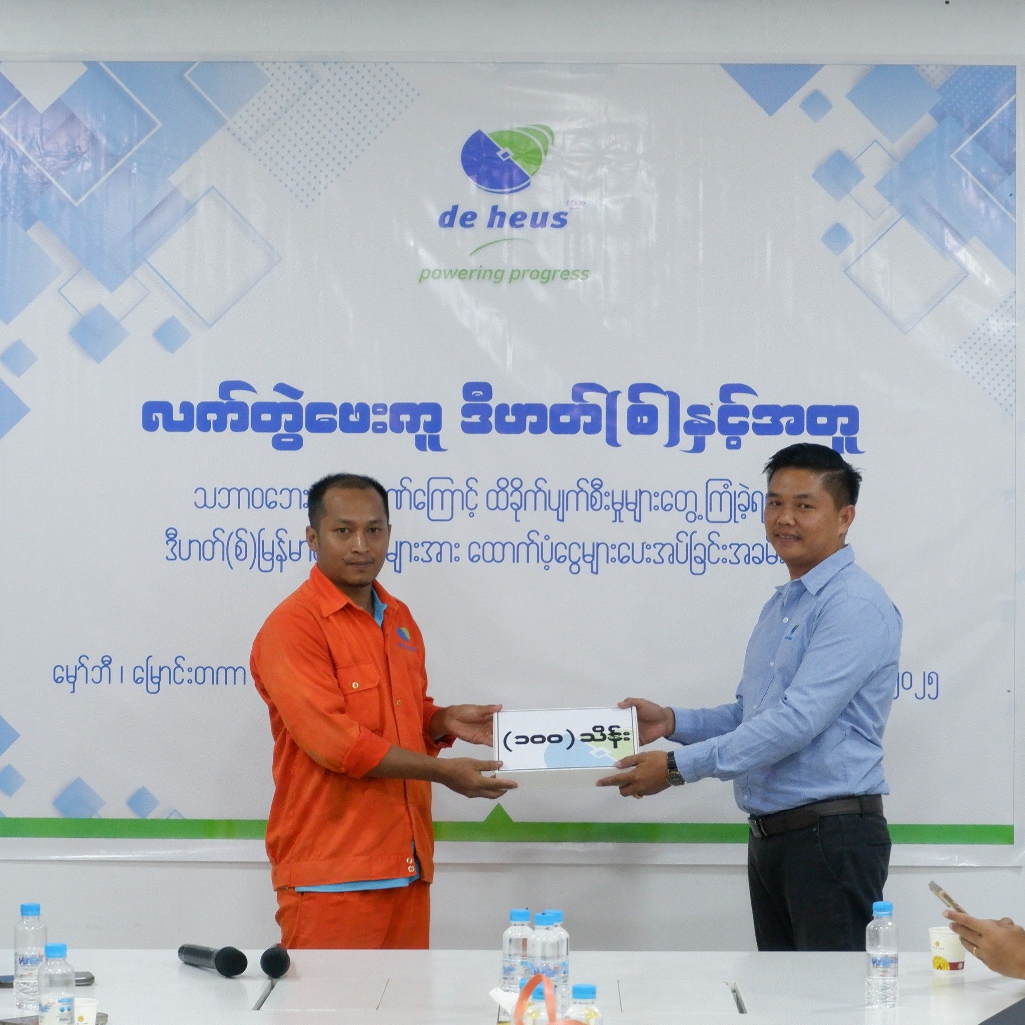 a factory employee is accepting a gift box from a man