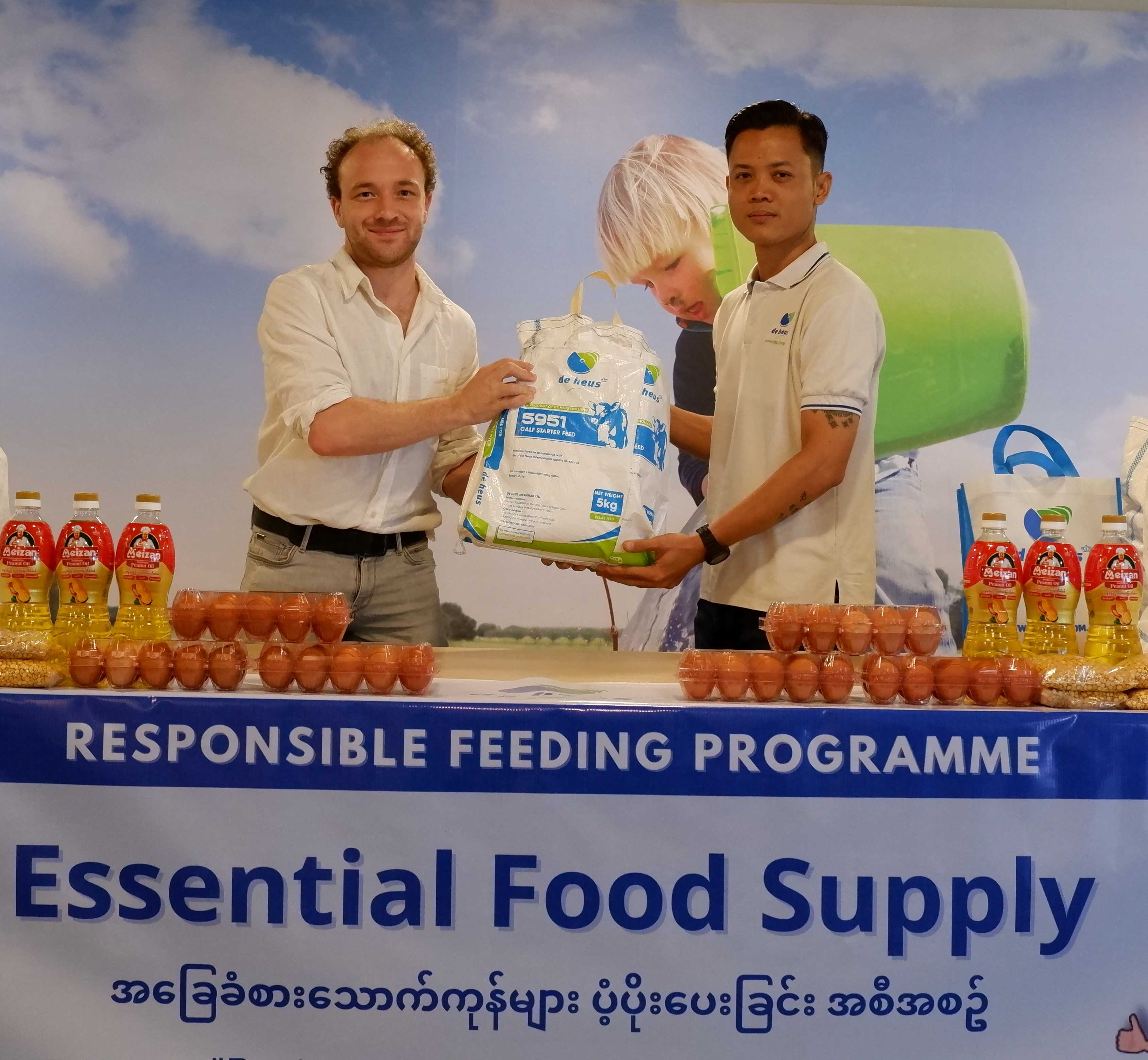 One foreigner is giving an animal feed bags to a local burma guy.