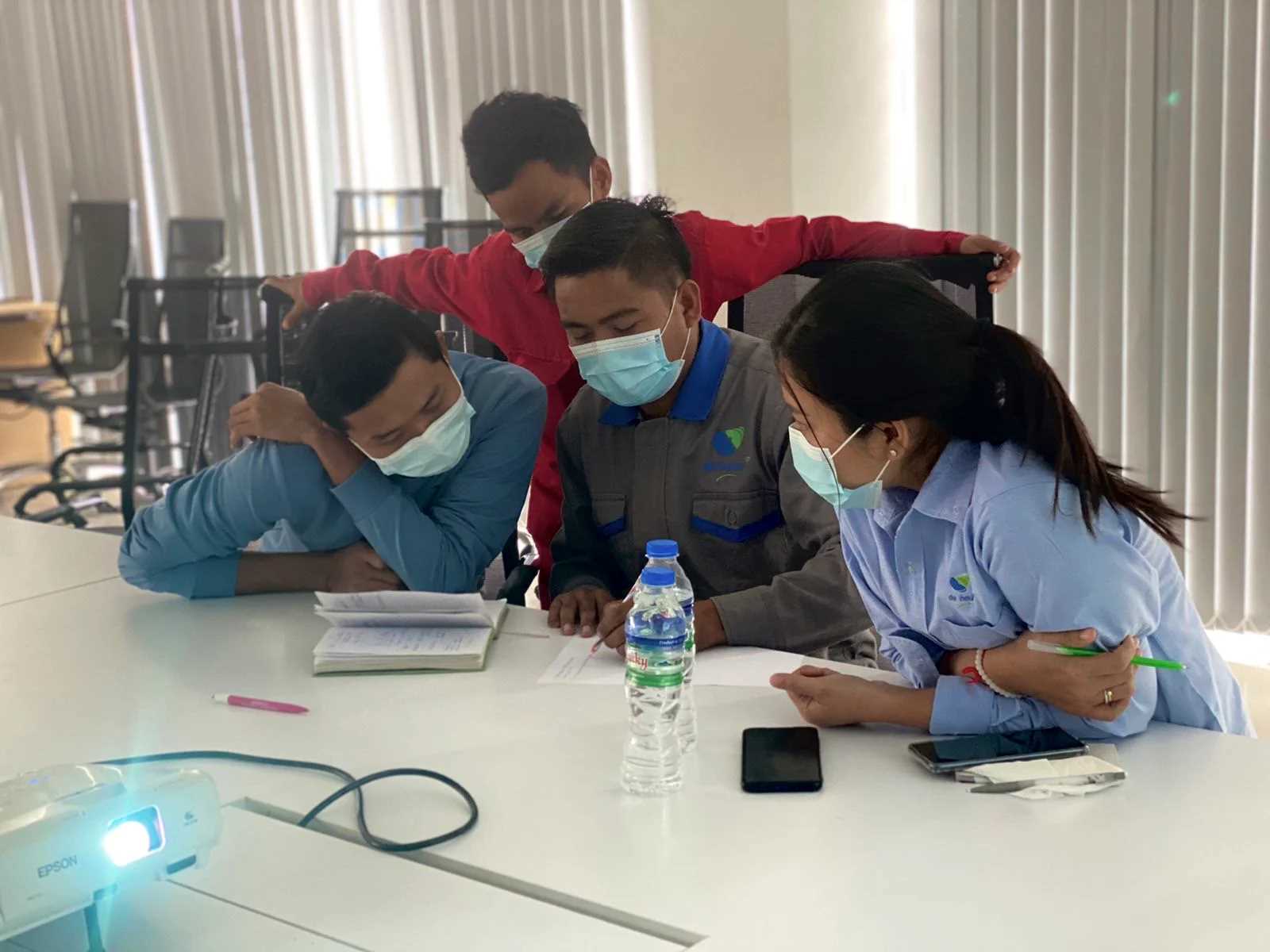 four people are discussing on a desk