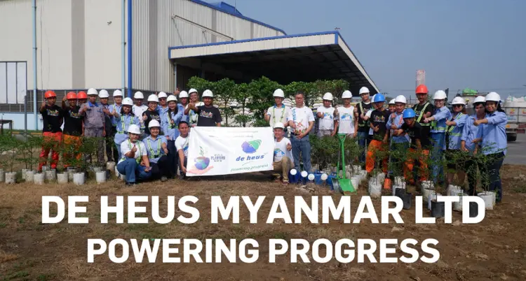 A group of factory workers are thumbing up with a vinyl sheet.