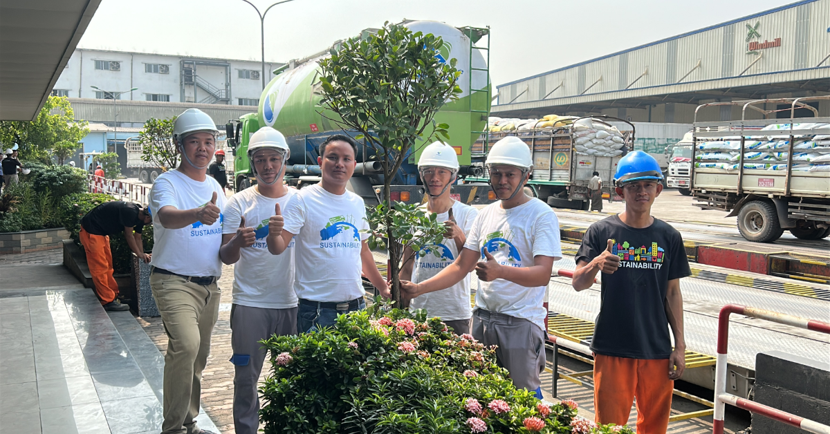 six people are thumbing up and two people are holding a tree to plant
