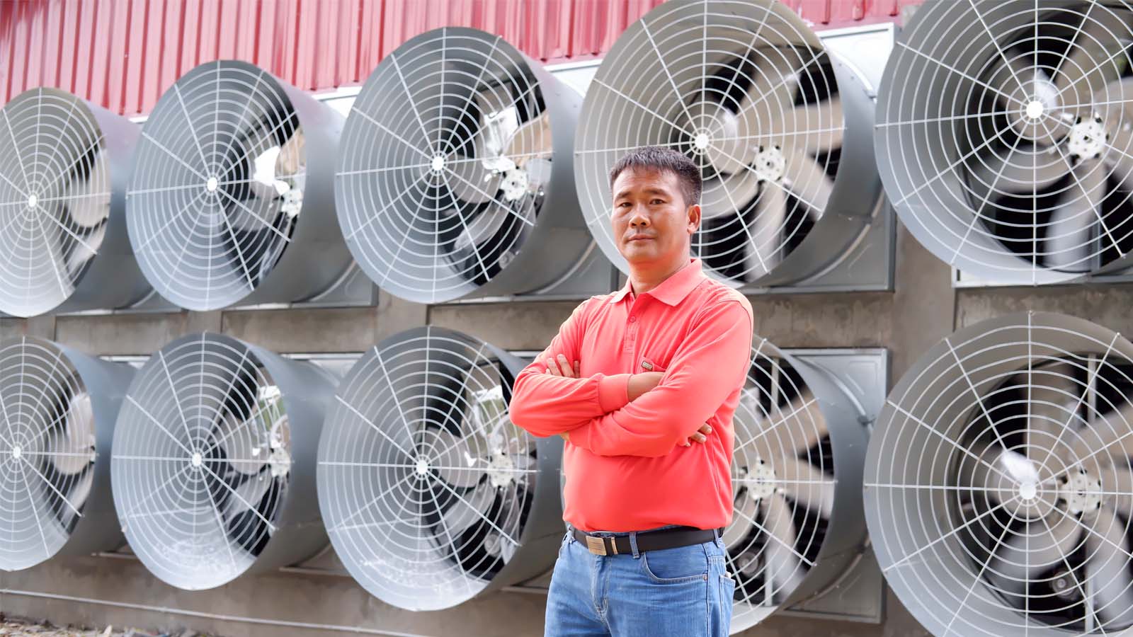 a Chinese man standing in front of the big fans in landscape.